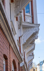 Fototapeta na wymiar Fassadenstuck unter Erker an Häuserzeile im Jugendstil in Flensburg.