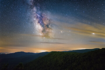 Fototapeta na wymiar The Milky Way shining through some partly cloudy skies over Shenandoah National Park in the Winter.
