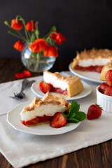 Slice of delicious strawberry tart with meringue on wooden background. Summer food. Soft focus