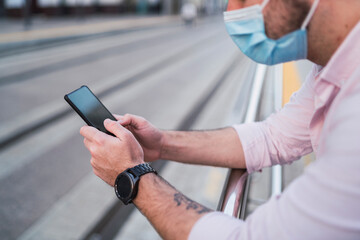 Chico joven atractivo usando tecnologia en la calle
