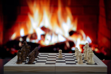 chess pieces on the chessboard against the background of the fireplace