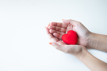 Female hands holding a red heart