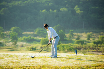 Golfer sport course golf ball fairway. People lifestyle man approach playing game golf tee off on the green grass.  Asian man player game shot in summer. 
