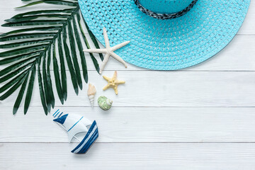 Summer Fashion tourism woman big hat and accessories to travel in the beach. Tropical sea. Unusual top view, wood white background