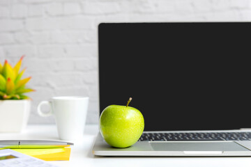 Healthy snack with working in office.  Green apple with laptop on white dress working.  Healthy Lifestyle Concept