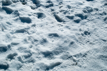 Background, texture. On the snow that fell, there were footprints from people's shoes.