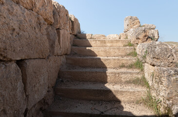 Fototapeta premium Remains of well-preserved stone steps in the ruins of the outer part of the palace of King Herod - Herodion,in the Judean Desert, in Israel