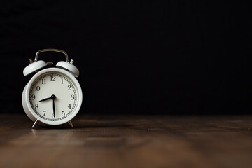 Retro alarm clock on wooden background. back to work and school concept.
