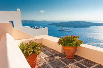 Santorini island, Greece. Flowers on the terrace with sea view. Travel destinations concept