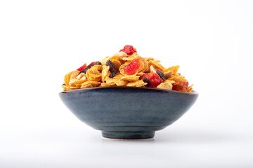 Homemade caramel cornflakes with cashews and raisins in a big bowl on white background. Side view.