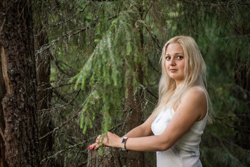 blonde girl in a white dress in the woods, selective focus