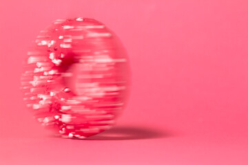 Donut in speed motion isolated on colored studio background. Round cake with hole, concept holiday fun, tasty food