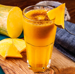 Spicy pumpkin cocktail on wooden cutting board. Halloween, Thanksgiving. Traditional autumn, winter drink and cocktail.
