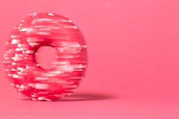Donut in speed motion isolated on colored studio background. Round cake with hole, concept holiday fun, tasty food