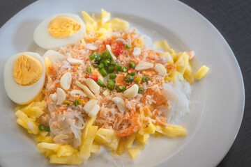 Thai rice noodles with pineapple and coconut milk the delicious of traditional food served on white plate in Thai name is Kanom Cheen Saw Num.