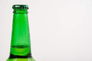 green glass bottle covered with water drops. condensate
