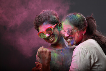 Young woman and her son plays with Holi festival colours.Concept for Indian festival Holi