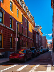 Street with red brick buildings on blue sky background