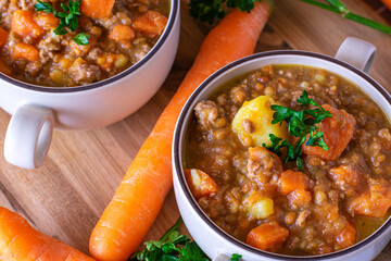 Lentil soup with carrots, potatoes and minced meat in a soup cup
