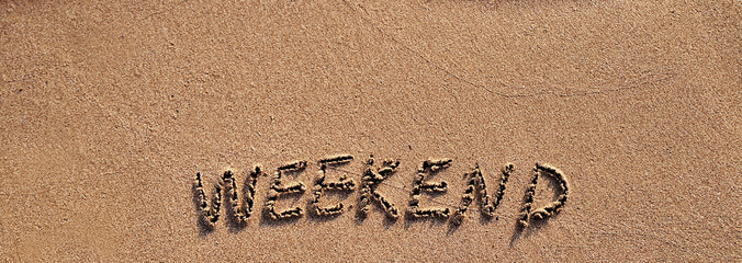 The word weekend written on sand