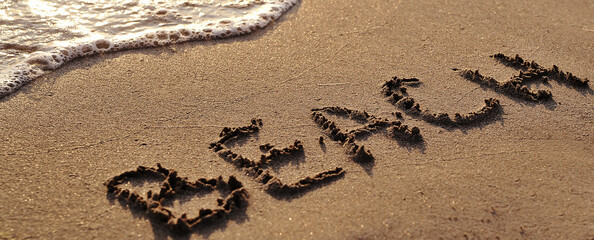 Fototapeta premium The word beach written on sand
