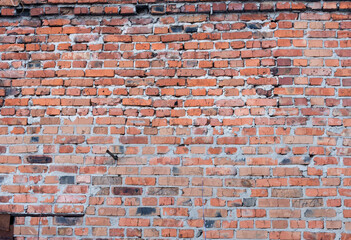 an old red brick wall with uneven masonry