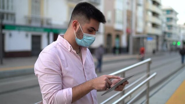 Chico joven atractivo usando tecnologia en la calle