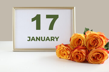 day of the month 17 January calendre photo frame and yellow rose on a white table
