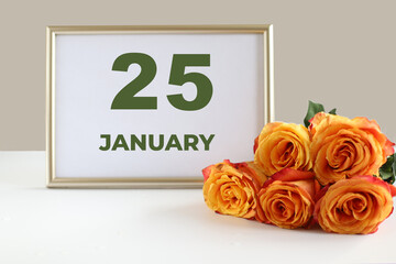 day of the month 25 January calendre photo frame and yellow rose on a white table