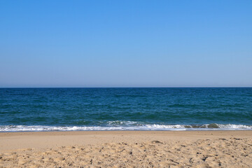 Fototapeta na wymiar empty sandy beach, sea horizon and clear sky