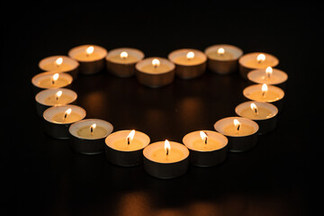 candles burning at night.Many candle flames glowing on dark background