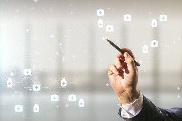 Man hand with pen working with abstract virtual medical hologram on blurred office background,...