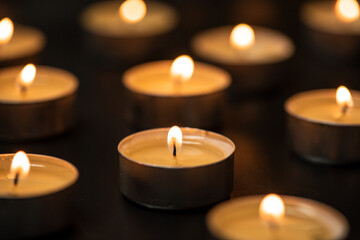 candles burning at night.Many candle flames glowing on dark background