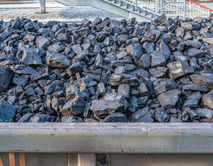 A hopper car is full of brown coal. Close-up.