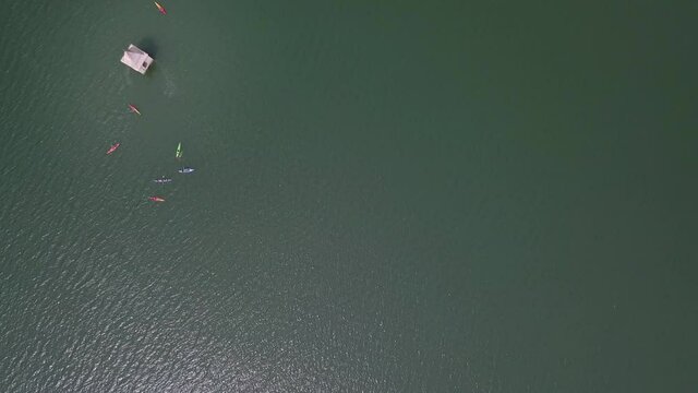 Aerial: Tourists Kayaking By Church Tower On Reservoir