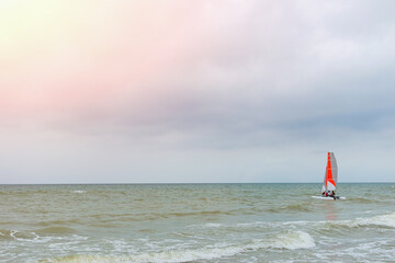 Small boat with a sail at sea. Sailing, active leisure concept.