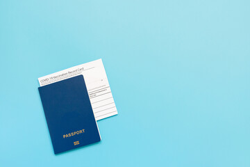Vaccination card, passport, a vial with covid-19 vaccine. syringe and mask on a blue background, close up, copy space. Immunity passport, risk-free concept.