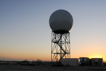 Weather surveillance radar in rural Arizona against a clear sky and sunset light