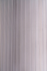 Obraz premium The texture of the wall is made of metal coating of huge aluminum plates of relief shape with horizontal notches. A variety of metal siding close-up