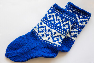 Warm knitted socks. Handmade work is always pleasant for yourself and for your family. A blue-and-white ornament adorns the socks.