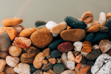Colorful sea pebbles close-up. Background texture, sea stones in the water