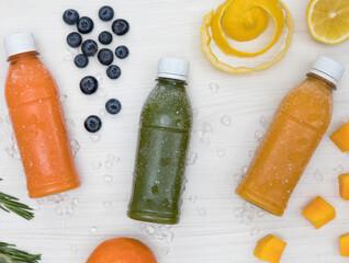 Bottles of fruit juice with fresh fruits on white background 