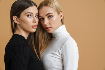 Beautiful young two women posing and hugging on camera