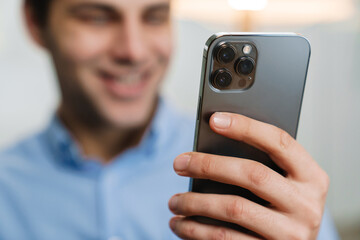 Smiling handsome young entrepreneur using mobile phone