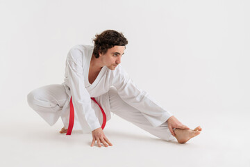 Confident young karate man warming up isolated