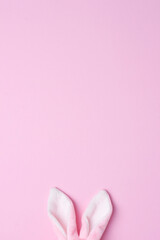 Bunny ears on pink background. Flat lay, copy space