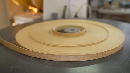 Veneered furniture edge on a roll on a machine. Furniture edge in furniture production.