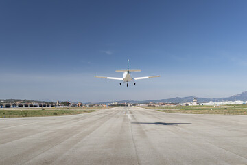 Light propeller aircraft landing on runway, close up symmetrical view