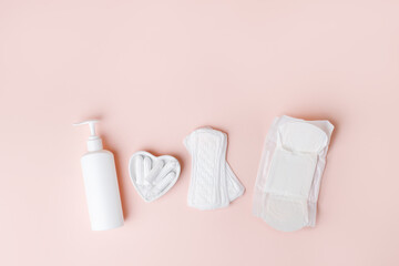 Tampons, feminine sanitary pads, liquid intimate soap on a pink background. Hygiene care during critical days. Menstrual cycle. Caring for women's health. Monthly protection, copy space