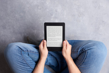 Subjective view of a young person reading a text on an electronic reader.
